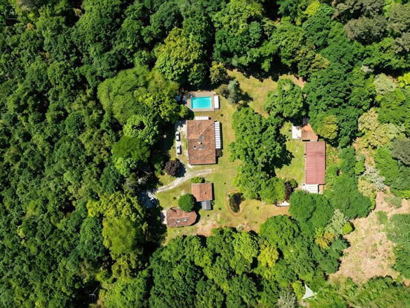 Vue aérienne d’un quartier résidentiel comprenant plusieurs immeubles, une piscine et de nombreux espaces verts.