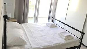 A bed with white linens, a metal frame, and a window with curtains. - Pegasus Amazing Flat, 1,5min Walk To The (Chania)