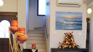 Uma sala de jantar com uma mesa comprida, centros de mesa decorativos e um quadro na parede.