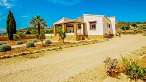 A single-story house with a covered porch, a stone foundation, and a gravel driveway. - Quicano - magnificent views and private pool in Lliber (Lliber)