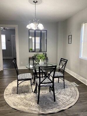 Enjoy meals in this stylish dining area with a round table, six chairs, and a chandelier.