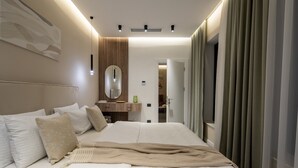 Une chambre d’hôtel moderne, avec un lit bien fait, un grand miroir et une vue sur le couloir.