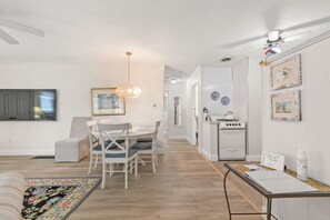 Una sala moderna con comedor, cocina y un pasillo.