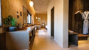 A modern bathroom with a central sink, a mirror, and a wooden door. - Steppe Valley Resort (Xing'an)
