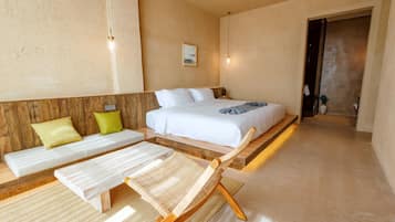 A bedroom with a bed, two bedside tables, a bench, and a chair.