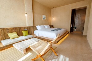 A bedroom with a bed, two bedside tables, a bench, and a chair.