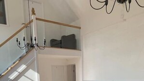 A modern living room with a sectional sofa, a wooden coffee table, and a staircase leading to an upper level. - Bodham House & Halls - 9 bedrooms (Bodham)