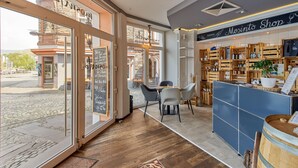 Een knus interieur met een bar, houten meubels en uitzicht op de straat.