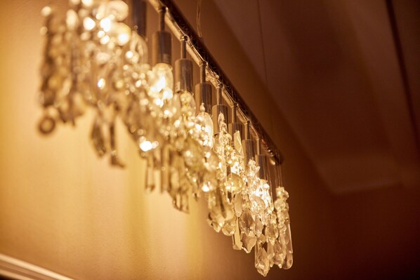 A chandelier with multiple crystal elements hanging from a ceiling fixture.