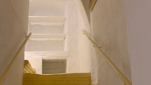 A staircase with white walls and a yellow handrail leading to an upper floor. - Valletta Studio (Valletta)