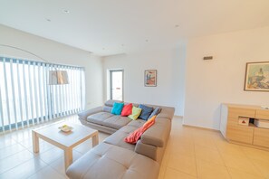Uma sala de estar moderna com um sofá, uma mesa de centro e um armário de madeira.
