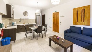 Una cocina moderna con comedor, un sofá y un cuadro en la pared.