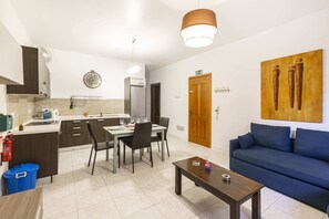 Departamento básico, varias camas | Área de sala de estar | Televisión