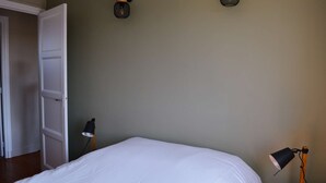 A bedroom with a bed, two wall-mounted lamps, and a door. - L'estran - Maison sur la Digue Avec vue mer (Courseulles-sur-Mer)