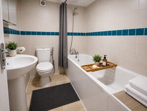Une salle de bain moderne équipée de toilettes, d’un lavabo, d’une douche et d’une baignoire.