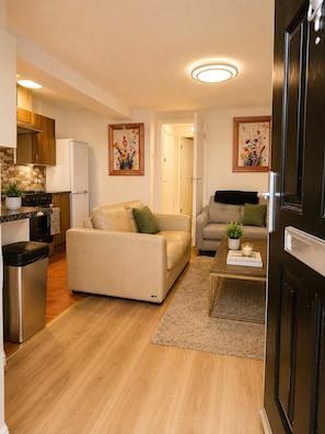 A compact living space with a kitchenette, two sofas, a coffee table, and a door. - Stylish Self-Catering Apartments (Liverpool)