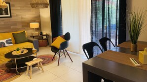 A modern living room with a sofa, chairs, a coffee table, and a dining table.