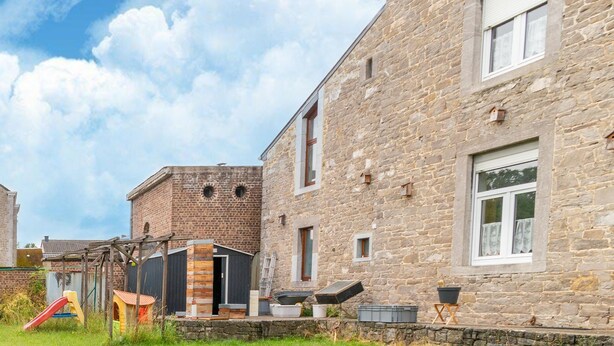A stone building with a wooden deck and a small play area with a slide. - Charming holiday home in Clavier with garden (Clavier)