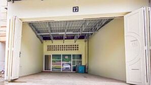 L'ingresso di un edificio con tetto in metallo, una porta con la scritta '17' e una porta in vetro con il cartello 'OYO'.