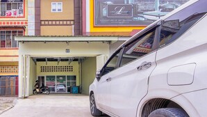 Un'auto bianca parcheggiata davanti a un edificio con un cartello pubblicitario di un bed and breakfast.