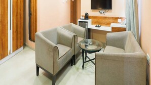 Ein modernes Wohnzimmer mit zwei Sofas, einem Couchtisch, einem an der Wand montierten Fernseher und einem Deckenventilator.