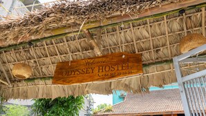A wooden sign with "Welcome to Odyssey Hostel" and a contact number. - Odyssey Hostel, Tours & Motorbikes Rental (Ha Giang 1)
