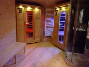 Un sauna avec des murs en bois, un banc et des portes en verre.