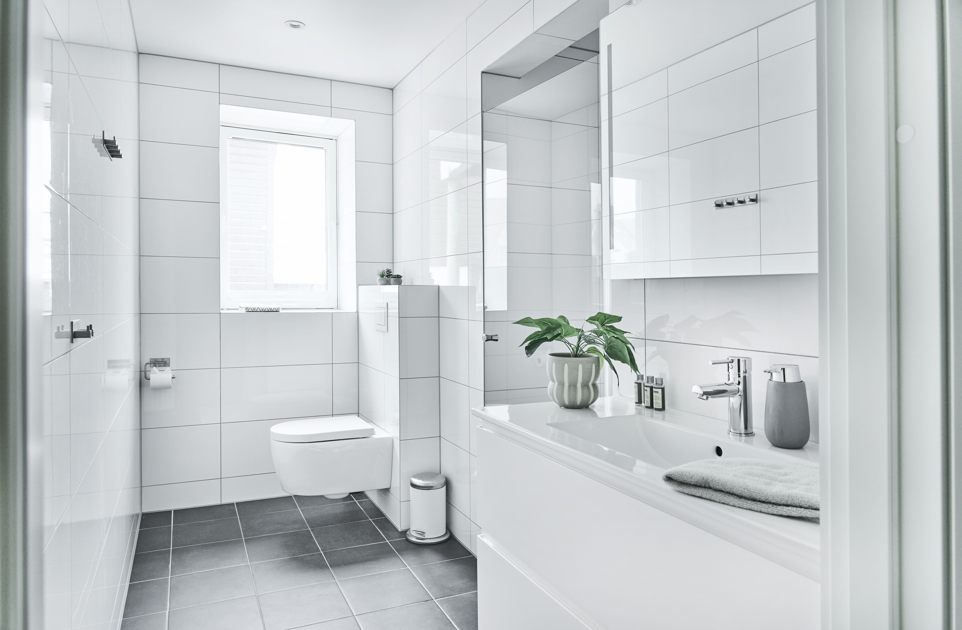 Un baño moderno con inodoro, lavamanos y espejo.