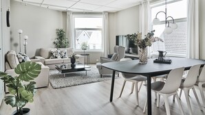 Una sala de estar moderna con sofá, mesa de centro y comedor.