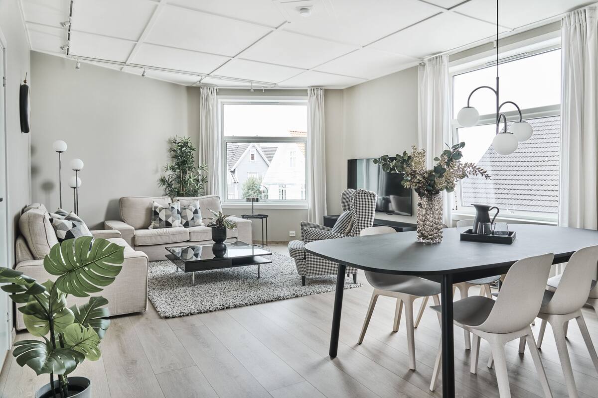 Een moderne woonkamer met een bank, salontafel en een eethoek.