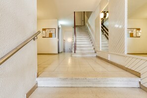 A staircase with a handrail, a tiled floor, and walls with bulletin boards. - Apartment "Roses Sweet Home" with Balcony & Wi-Fi (Roses)