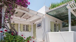 A white building with a porch, green shutters, and a door. - Holiday Home 'Green Retreats 5 Paros' with Mountain View, Wi-Fi and Air Conditioning (Glifades)