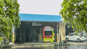 A roadside food truck with a yellow and red design, parked next to a building with a blue roof. - Hotel O Pondok Karisma Syariah (Tasikmalaya)