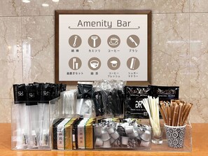 A hotel reception area with a framed sign listing amenities such as a comb, razor, coffee, and tea. - Green Rich Hotel Tokuyama Ekimae Artificial Hot Spring Futamata Yunohana (Shunan)