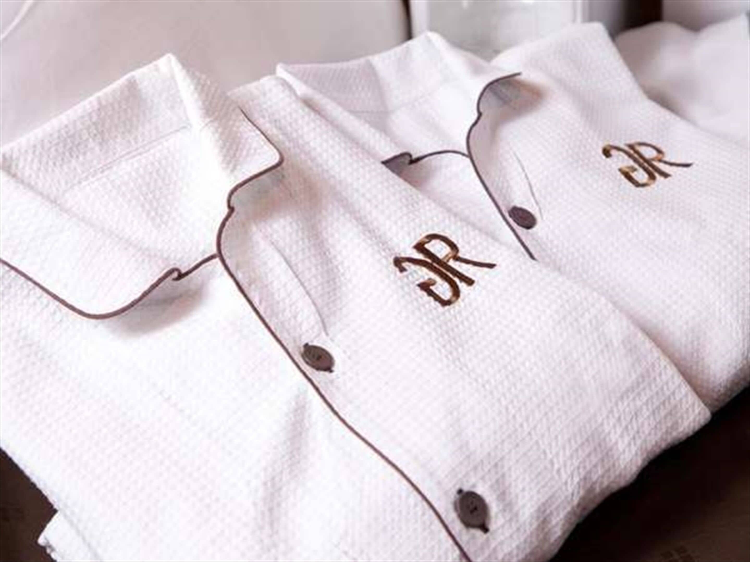A white shirt with a button and a monogram on the cuff.