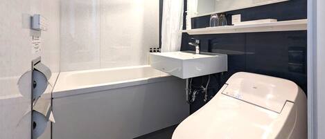 Un baño moderno con bañera, inodoro y lavamanos.