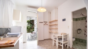 Een keuken met een spoelbak, een eettafel en een hangende lamp.