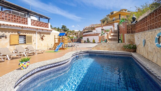 A swimming pool with a slide, lounge chairs, and a staircase leading to a building. - Villa 'Cal Ramon for 15 Guests' with Private Pool, Wi-Fi & Air Conditioning (Rubi , Barcelona)