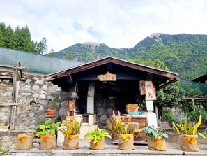 Un bâtiment rustique avec un mur en pierre, des poutres en bois et une enseigne sur laquelle on peut lire « ESTINTORE ».