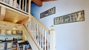 A wooden staircase leading to a dining area with a kitchen in the background. - Beautiful 'Adamello 7' Apartment with Wi-Fi (Pinzolo)