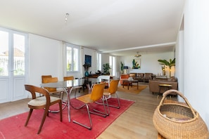 A spacious living area with a dining table, chairs, a sofa, and a coffee table. - Holiday Home 'Villa Tamois' with Private Garden and Wi-Fi (Soustons)