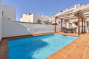 Une piscine sur le toit, agrémentée d’une pergola et d’un espace salon extérieur.