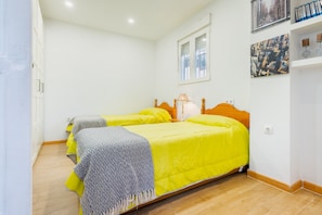 A room with two beds, a window, and a wall with framed pictures. - Holiday Home with Private Pool and A/C near Seville (La Rinconada)