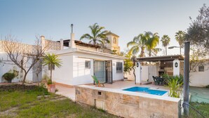 A house with a swimming pool, a patio with chairs, and a garden. - Holiday Home with Private Pool and A/C near Seville (La Rinconada)