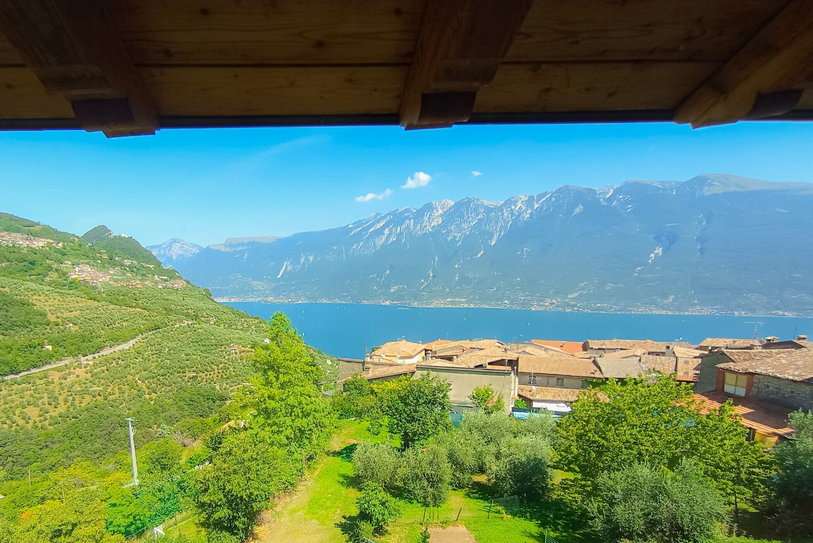 Une vue depuis une structure en bois surplombant un paysage montagneux, avec un lac et des bâtiments.