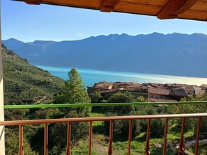 A coastal view with mountains, a beach, and a village. - Apartment 'Naol' with Lake View (tignale)