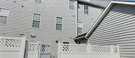 A residential building with a sloped roof and multiple windows.
