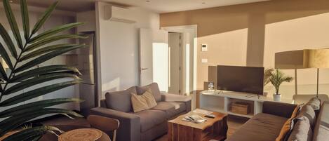 A modern living room with a sofa, coffee table, and television.