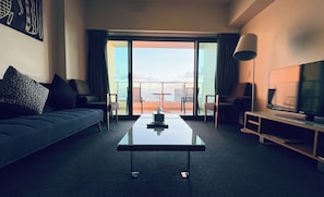 Relax in a stylish room with a sofa, flat-screen TV, and city views from the balcony.