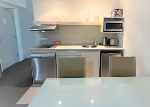 Compact kitchen area with oven, microwave, and sink, perfect for preparing meals.
